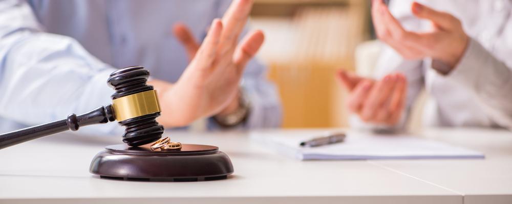 Divorcing Couple Discussing With Gavel And Rings in Front Of Them In A Jefferson Park Attorney´s Office