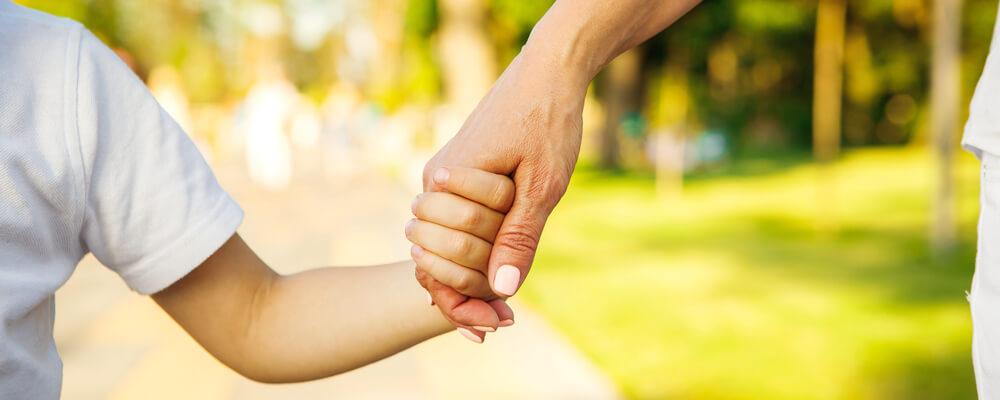 Mother and son holding hands at the park after child custody battle in Chicago